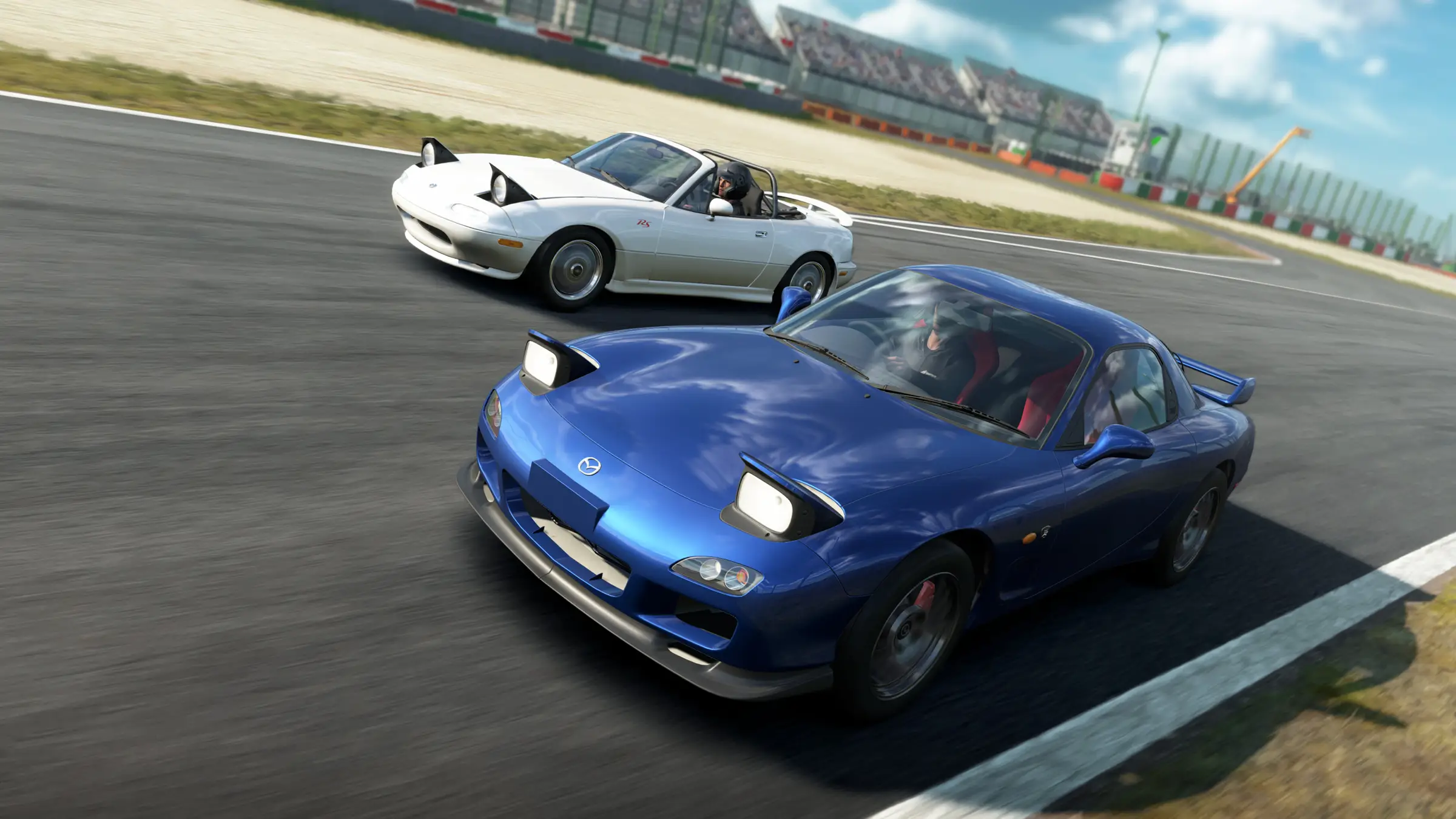 Hosting server Assetto Corsa EVO: una Mazda RX-7 blu insegue una Mazda MX-5 bianca in curva davanti alle tribune