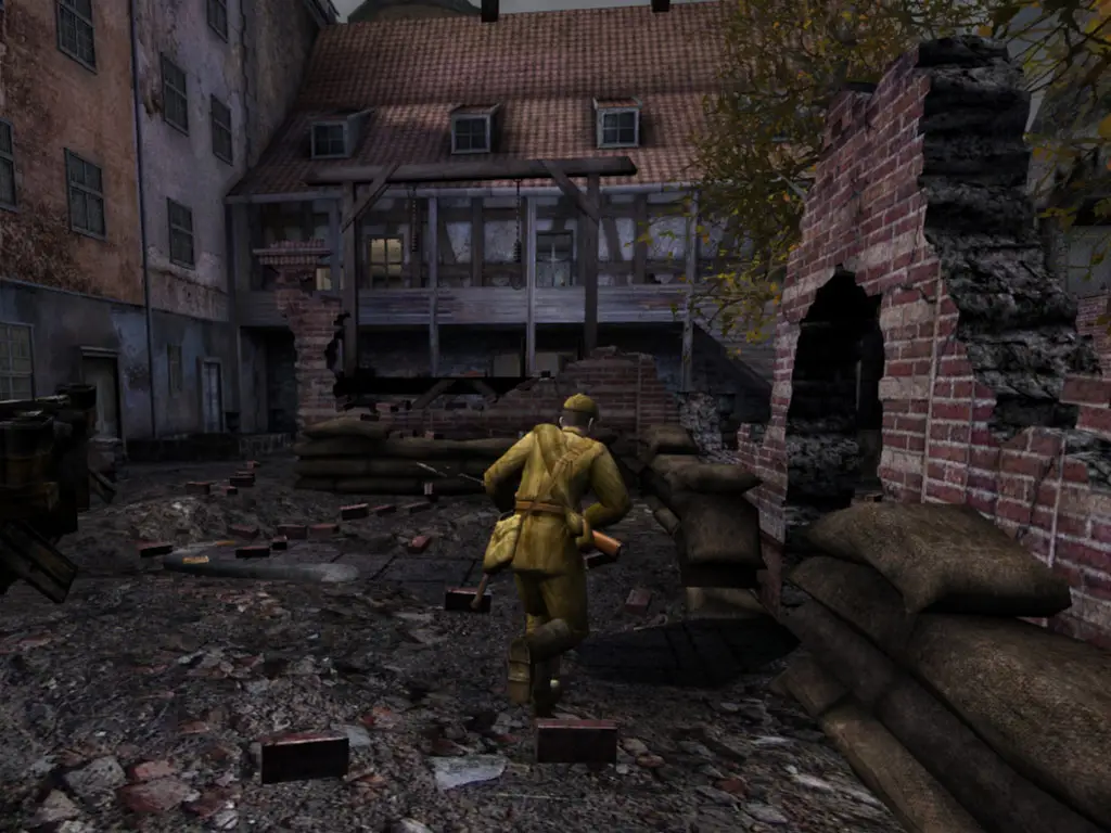 Red Orchestra server hosting: a Soviet soldier runs past sandbags into a bombed-out courtyard of half-timbered houses